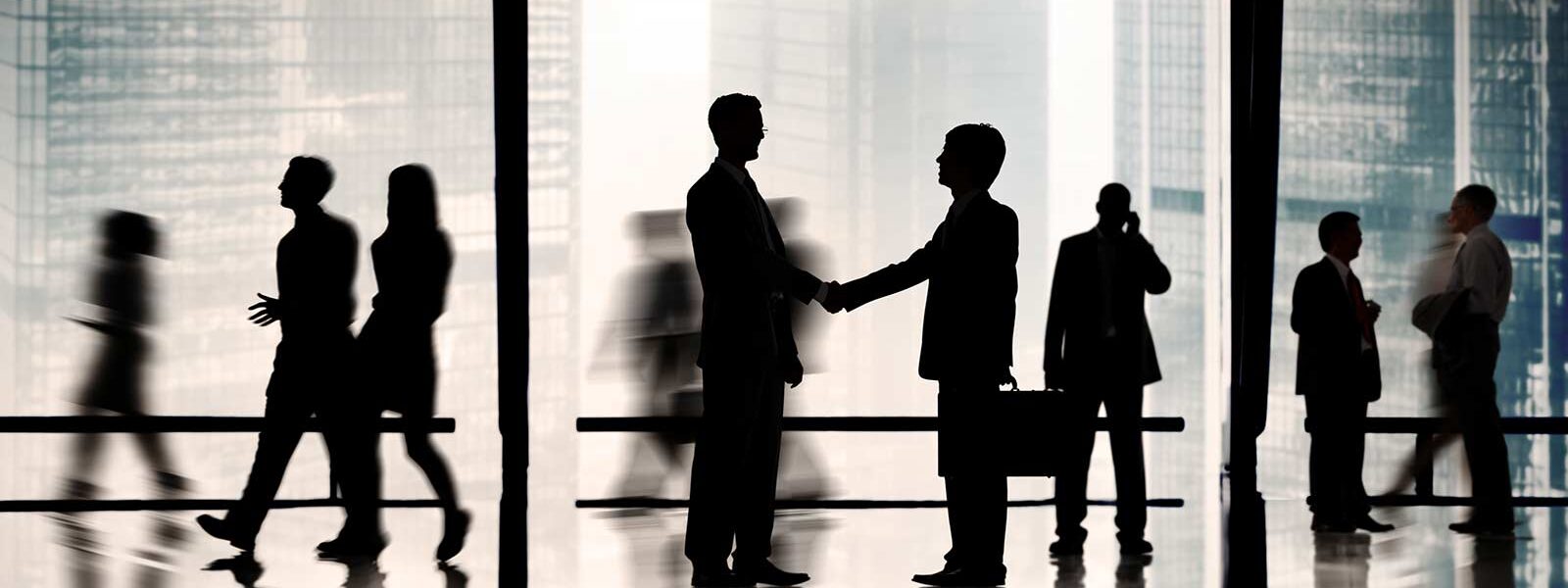 two men shaking hands and developing business acumen skills
